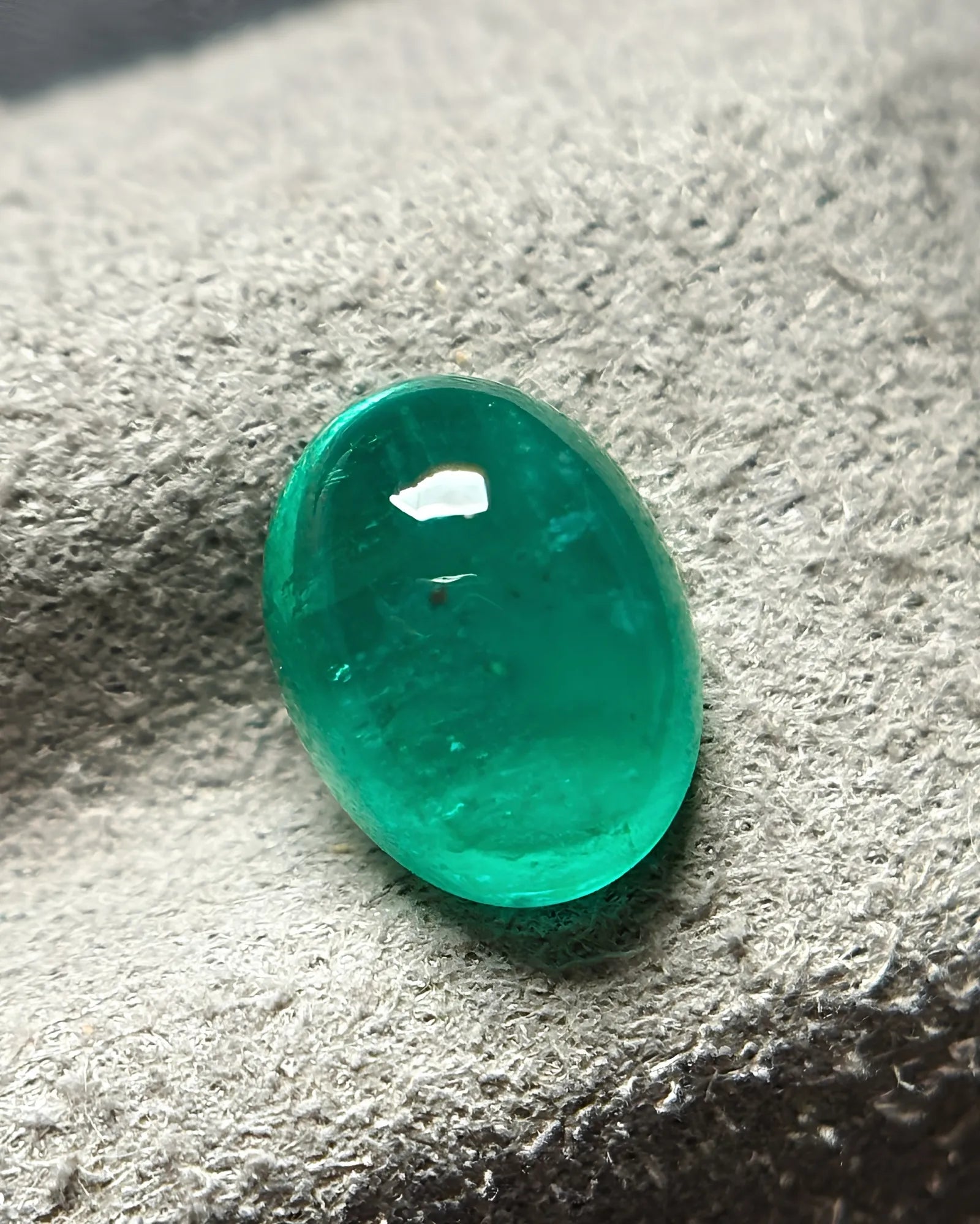 Close-up of polished green Emerald cabochon surface | SARATTI
