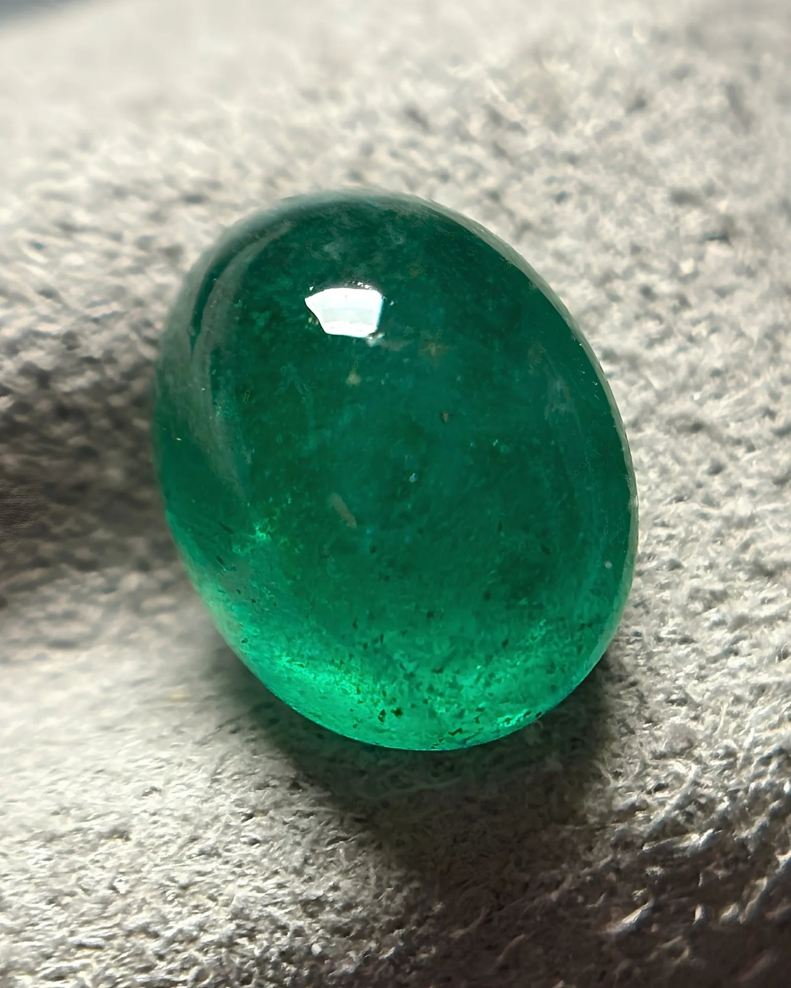 Close-up of polished vivid green Emerald cabochon surface - SARATTI