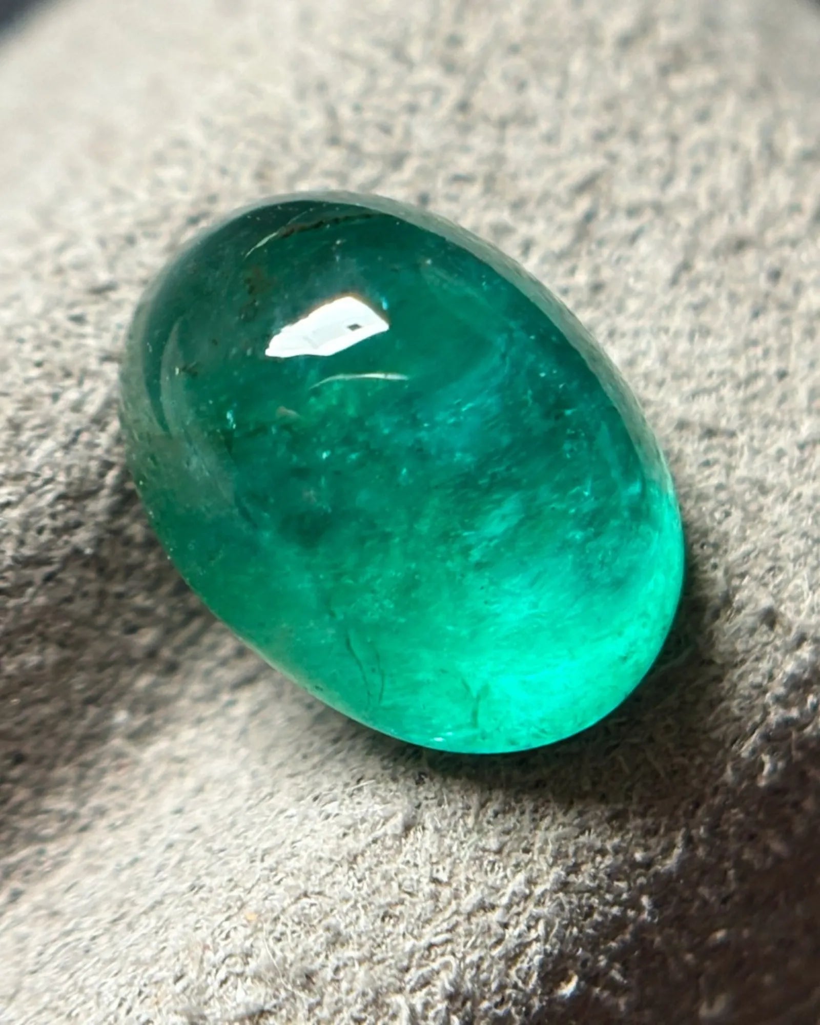 Close-up of polished vivid green Emerald cabochon surface | SARATTI
