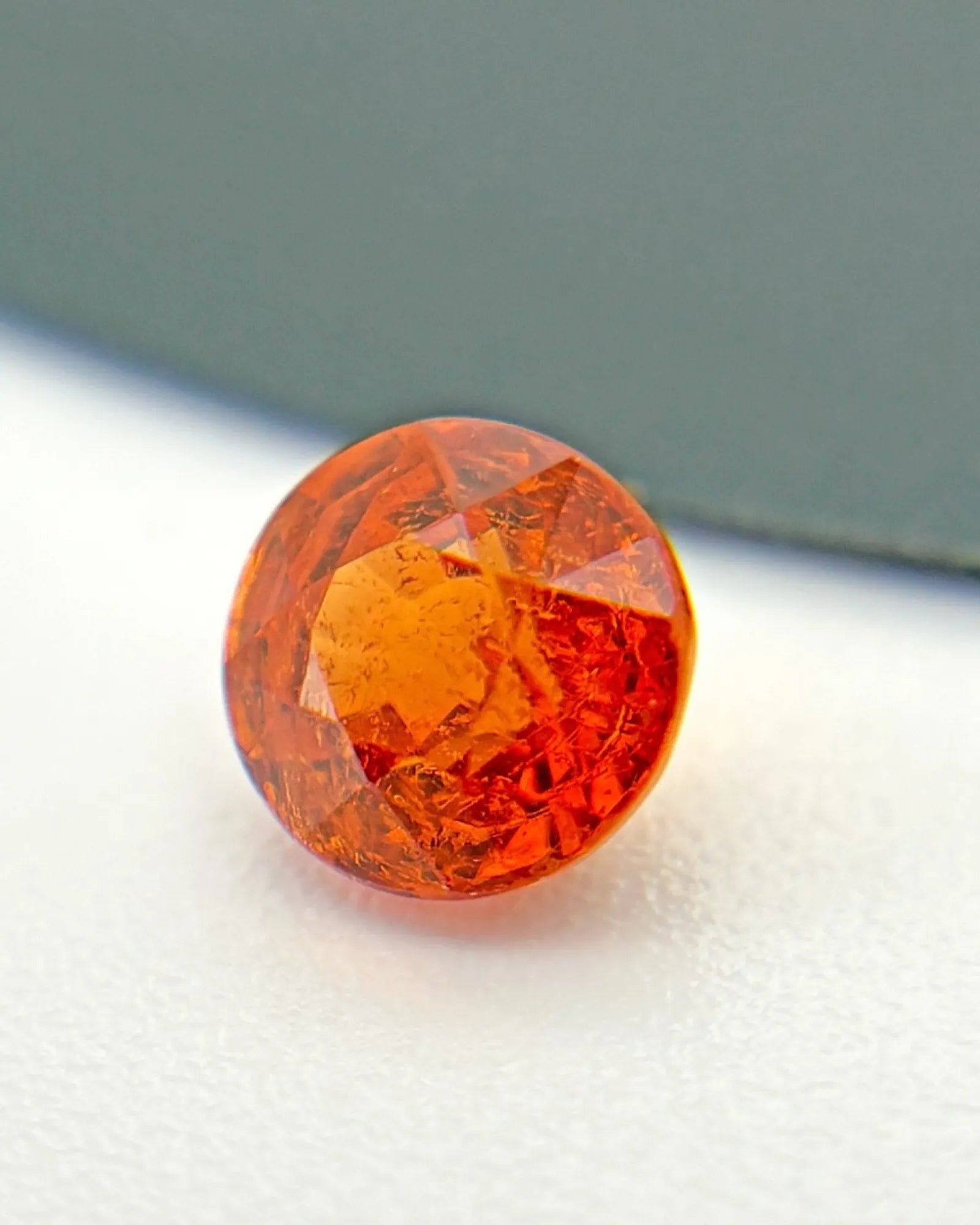 Close-up of round Spessartine Garnet faceted surface | SARATTI