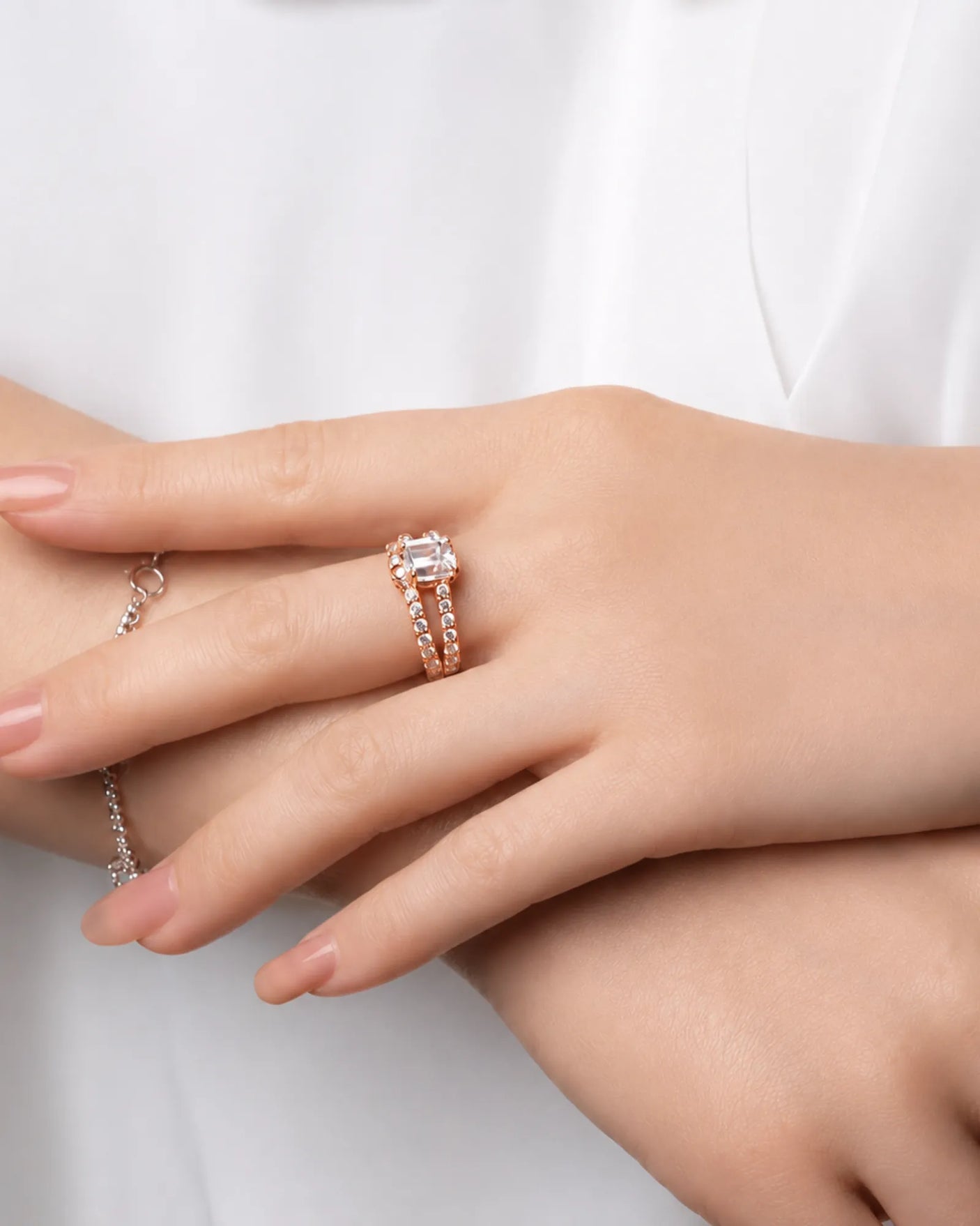 Colorless emerald-cut moissanite center with round accents in polished rose gold | SARATTI.