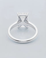 Colorless emerald-cut moissanite ring with step-cut facets and refined platinum setting | SARATTI