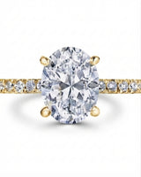 Colorless oval moissanite center with round pavé accents set in yellow gold | SARATTI