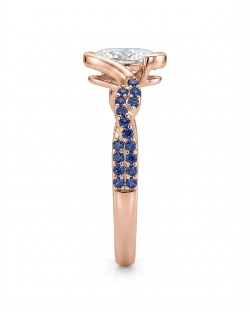 Colorless oval moissanite framed by vivid blue sapphires in polished rose gold | SARATTI