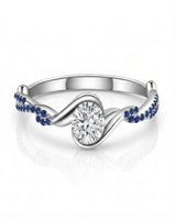 Colorless oval moissanite framed by vivid blue sapphires in polished white gold | SARATTI