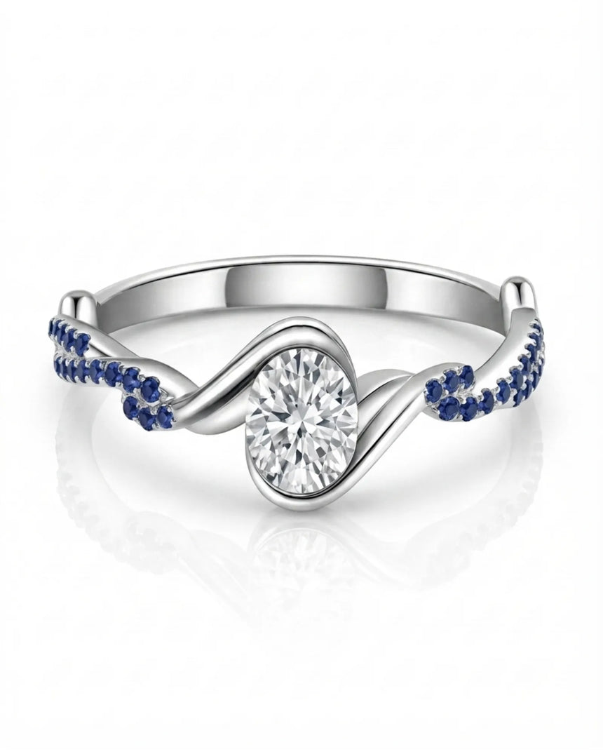 Colorless oval moissanite framed by vivid blue sapphires in polished white gold | SARATTI
