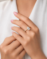 Colorless pear-shaped moissanite center with round accent stones and hidden halo in yellow gold | SARATTI