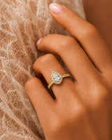 Colorless pear cut moissanite surrounded by brilliant round accents in polished 18K yellow gold | SARATTI