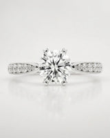 Colorless round moissanite center framed by pavé stones in polished platinum | SARATTI