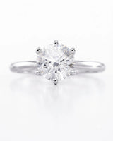 Colorless round moissanite ring with open gallery and elevated white gold six-prong profile | SARATTI