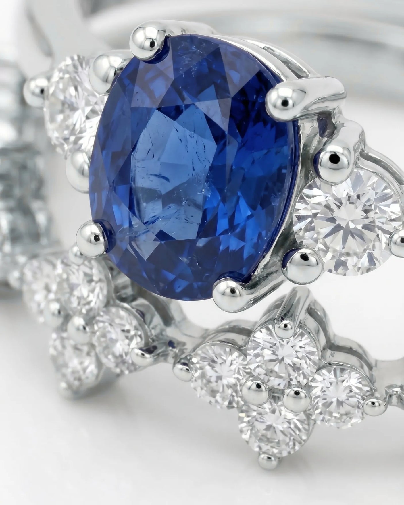Cushion blue sapphire ring with diamond side stones and matching band in platinum | SARATTI