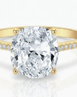 Cushion moissanite center stone ring with round side stones in yellow gold | SARATTI