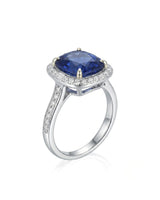 Cushion royal blue sapphire ring with diamond halo and shoulder stones in 18K white gold | SARATTI