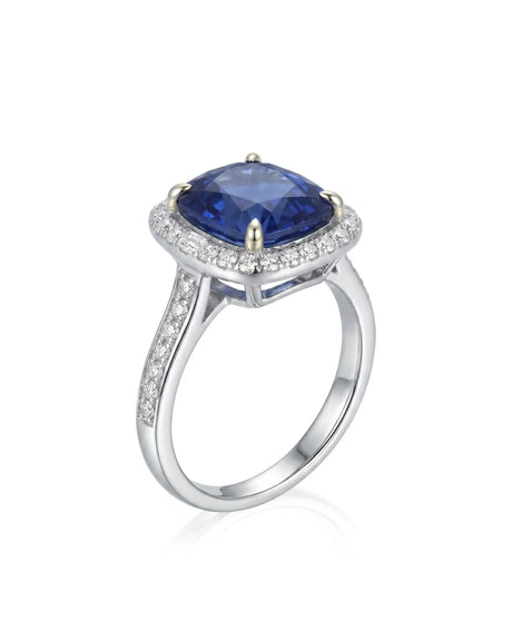 Cushion royal blue sapphire ring with diamond halo and shoulder stones in 18K white gold | SARATTI