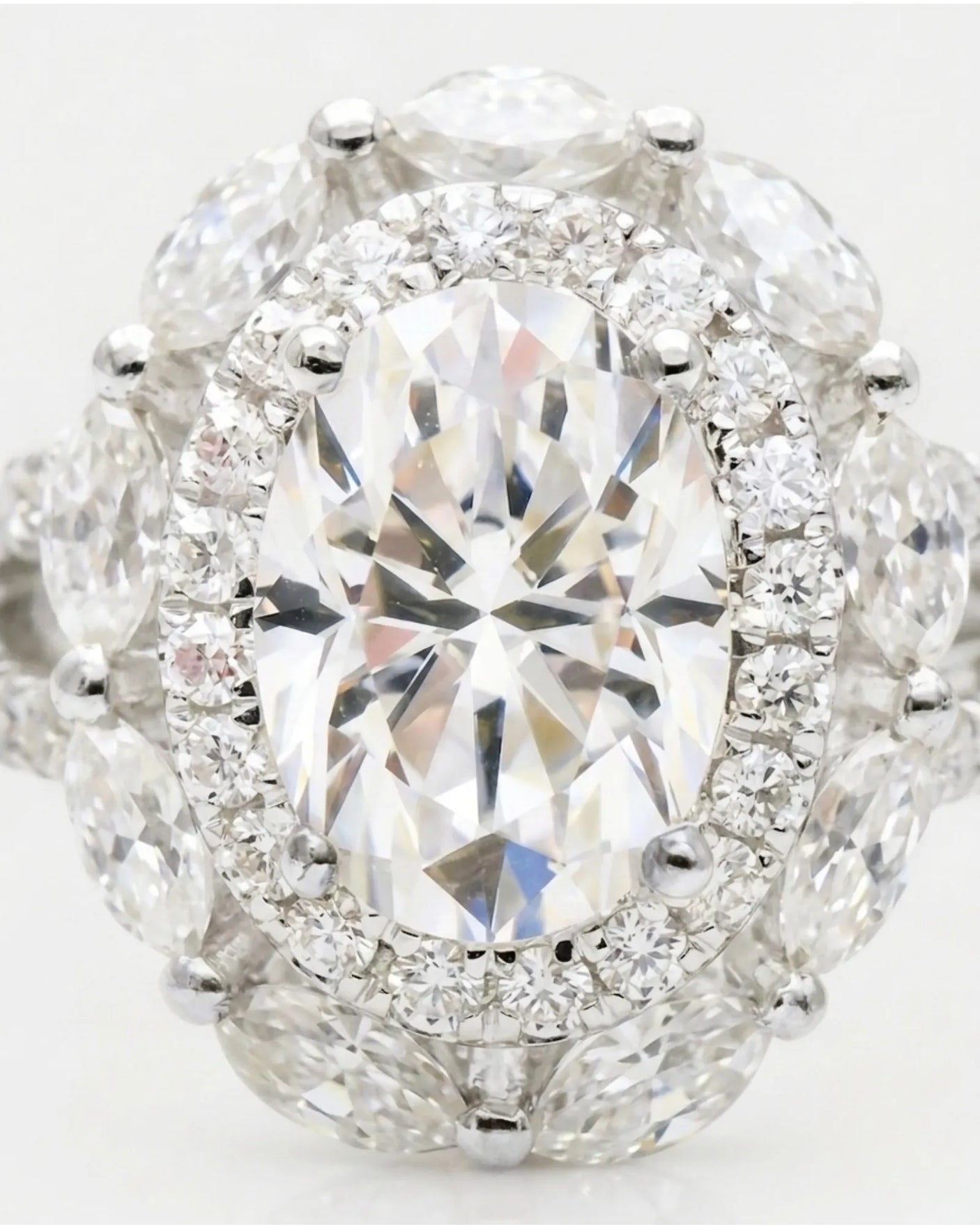 D color oval moissanite center framed by round and marquise stones in 18K white gold | SARATTI
