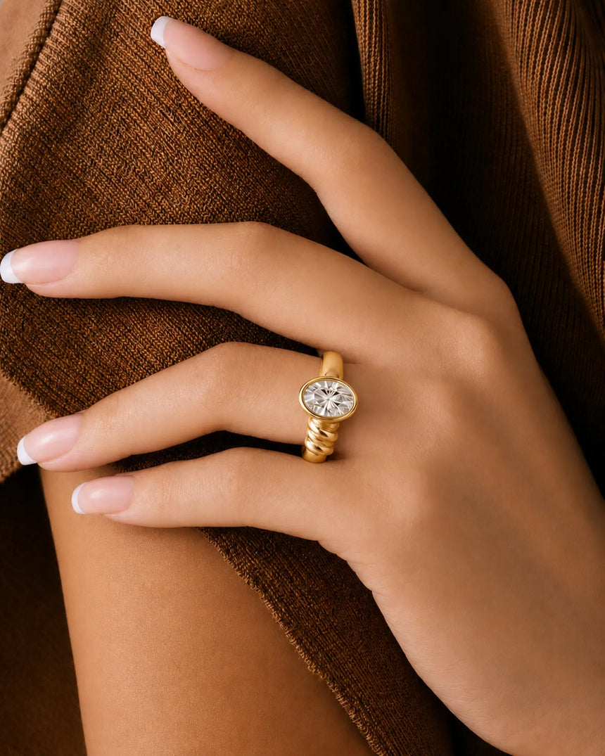 D color oval moissanite framed by a smooth bezel in warm 18K yellow gold | SARATTI