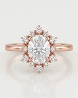 D color oval moissanite framed by round moissanite stones in polished 18K rose gold | SARATTI