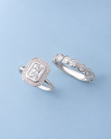 D color radiant moissanite center framed by round moissanite accents in enduring platinum | SARATTI