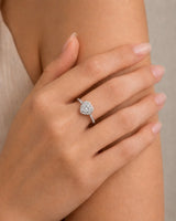 D colorless heart moissanite ring framed by round accent stones in 18K white gold | SARATTI