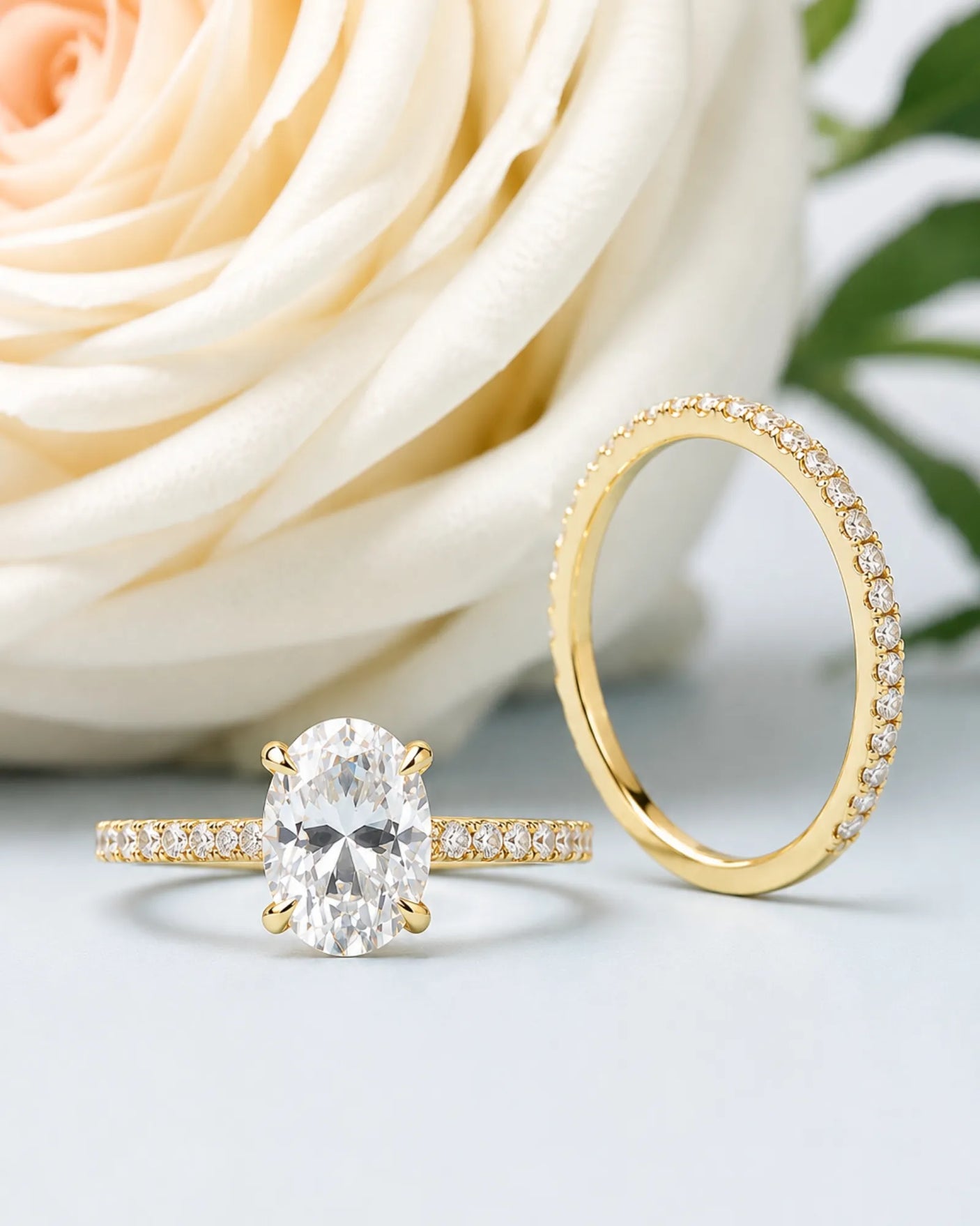 D colorless oval moissanite engagement ring with round accent stones and 18K yellow gold wedding band | SARATTI