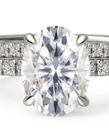 D colorless oval moissanite engagement ring with round accent stones and matching platinum wedding band | SARATTI