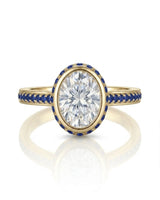 D colorless oval moissanite framed by vivid blue sapphires in polished 18K yellow gold | SARATTI