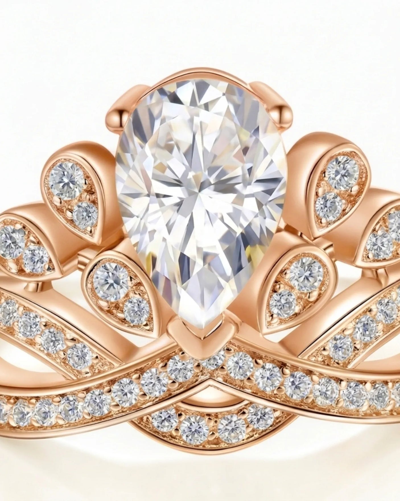 D colorless pear moissanite ring framed by round accent stones in 18K rose gold | SARATTI