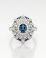 Deep London Blue oval topaz ring framed by round diamonds in platinum | SARATTI