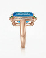 Elongated cushion Swiss Blue topaz ring bordered by baguette diamonds in polished 18K rose gold | SARATTI
