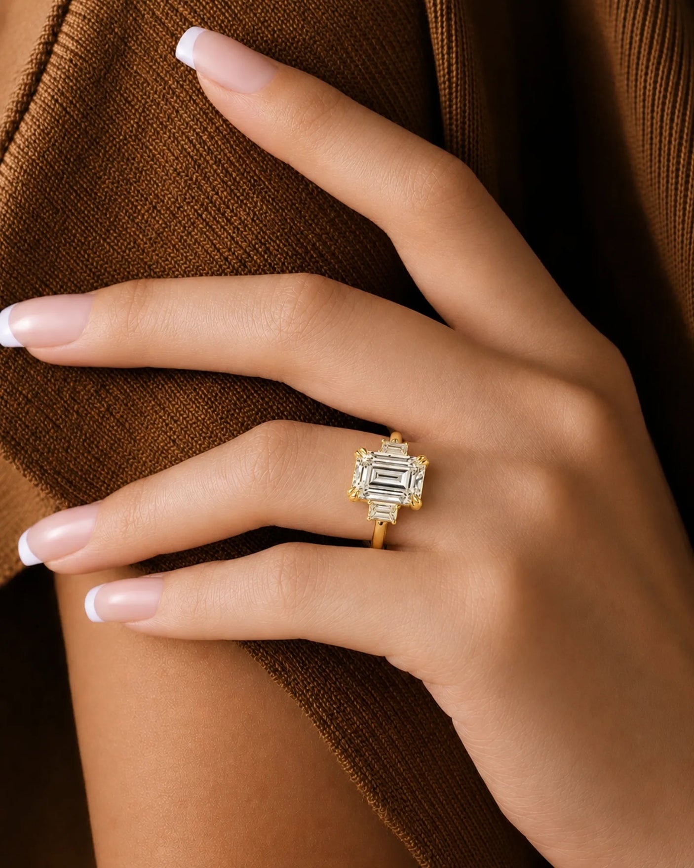 Emerald-cut center diamond framed by step-cut side diamonds in a warm yellow gold setting | SARATTI