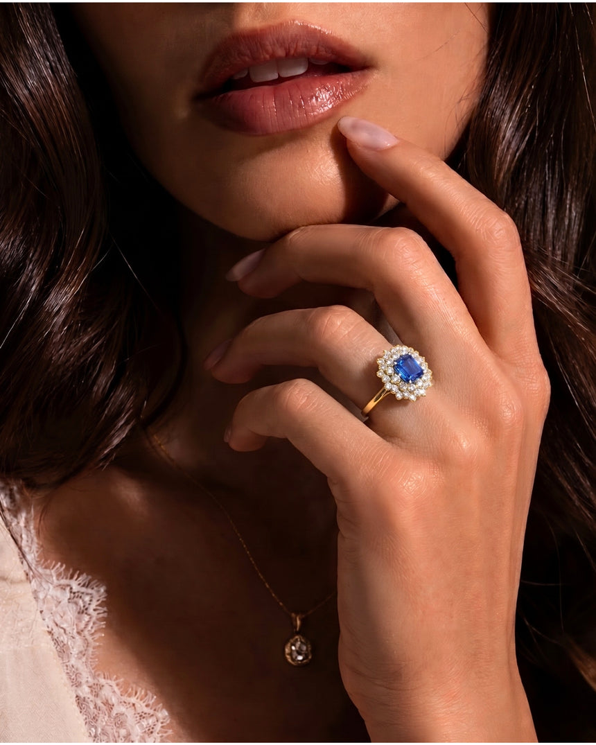 Emerald-cut royal blue sapphire ring framed by bright diamonds in 18K yellow gold | SARATTI