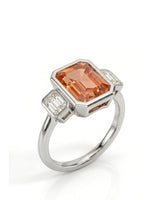 Emerald cut Natural Imperial Topaz three-stone bezel setting in platinum | SARATTI