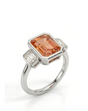 Emerald cut Natural Imperial Topaz three-stone bezel setting in platinum | SARATTI