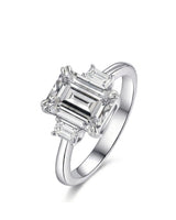 Emerald cut moissanite three stone engagement ring with matching side stones crafted in platinum | SARATTI