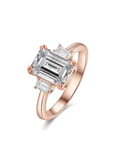 Emerald cut moissanite three stone engagement ring with matching side stones in 18K rose gold | SARATTI