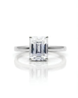 Emerald moissanite solitaire ring in platinum with architectural basket and clean minimalist profile | SARATTI