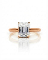 Emerald moissanite solitaire ring in rose gold with architectural basket and clean minimalist profile | SARATTI