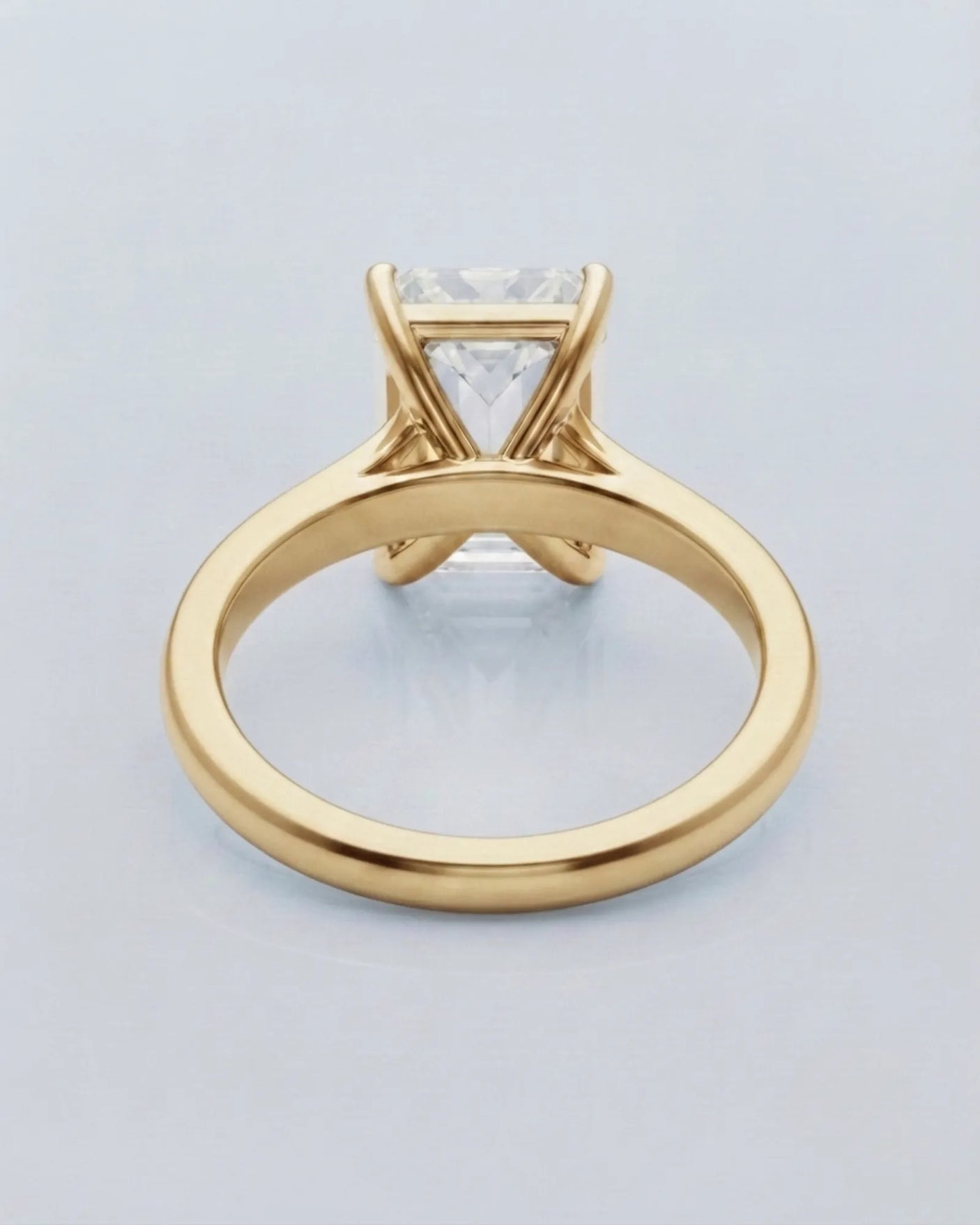 Emerald moissanite solitaire ring in yellow gold with architectural basket and clean minimalist profile | SARATTI