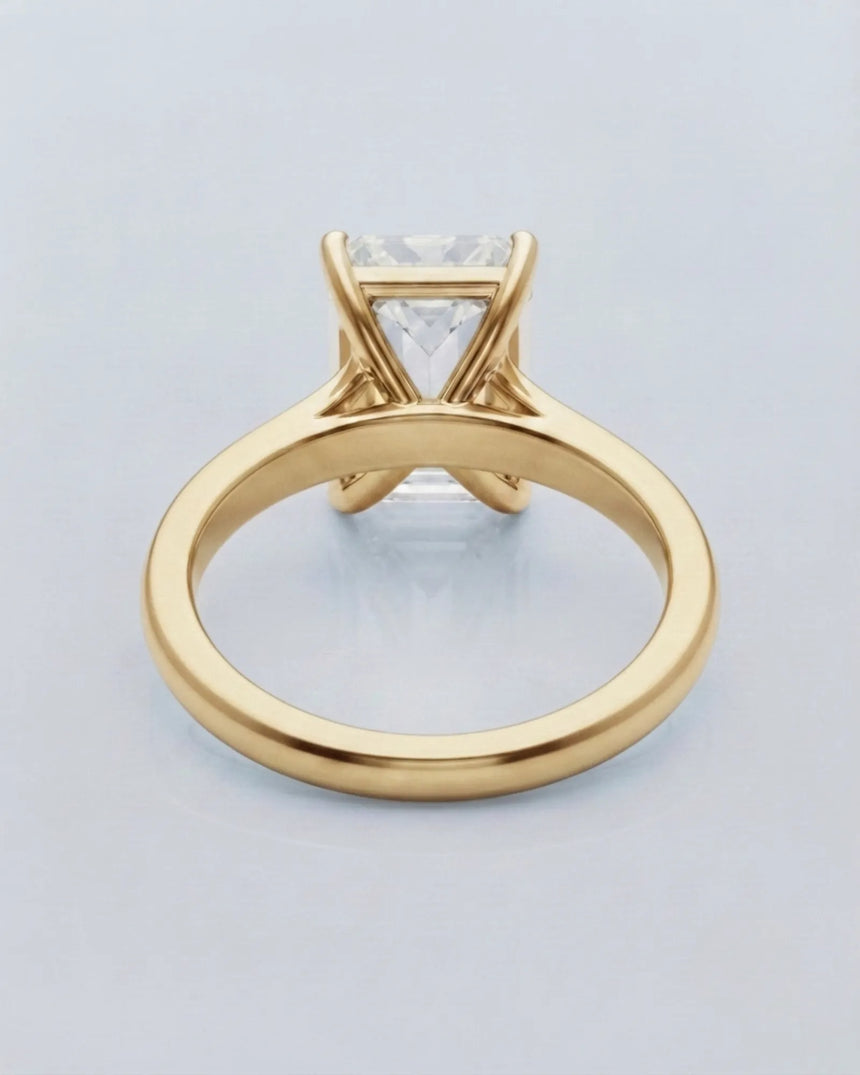 Emerald moissanite solitaire ring in yellow gold with architectural basket and clean minimalist profile | SARATTI