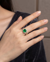 Emerald woven ring featuring a diamond halo and textured interlocking 18K two tone gold shoulders | SARATTI
