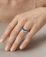 Geometric V-shaped sapphire ring with stepped baguette stones and round diamond border in platinum | SARATTI