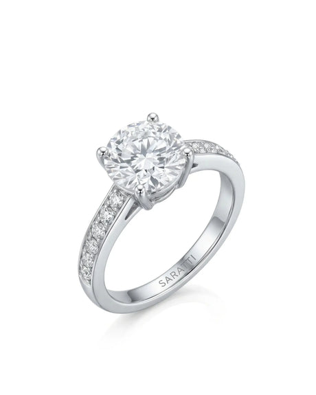 Layla round centre stone engagement ring 45-degree view with diamond-set shoulders in 18K white gold | SARATTI