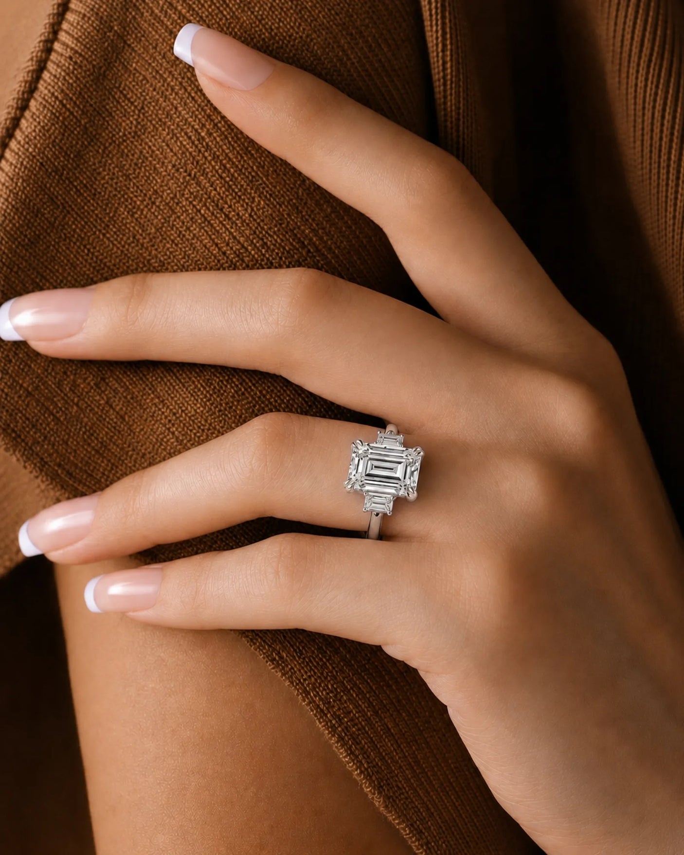 Luxury emerald-cut diamond engagement ring with side diamonds and sculpted platinum prongs | SARATTI