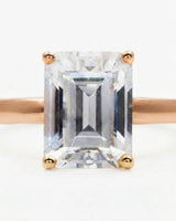 Luxury emerald-cut moissanite solitaire ring with polished rose gold band and open gallery | SARATTI