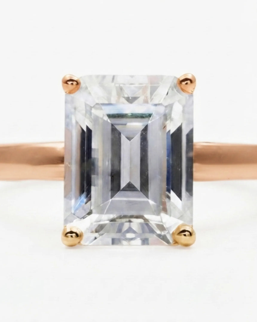Luxury emerald-cut moissanite solitaire ring with polished rose gold band and open gallery | SARATTI