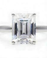 Luxury emerald-cut moissanite solitaire ring with polished white gold band and open gallery | SARATTI