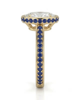 Luxury oval moissanite and natural sapphire ring with protective bezel in 18K yellow gold | SARATTI