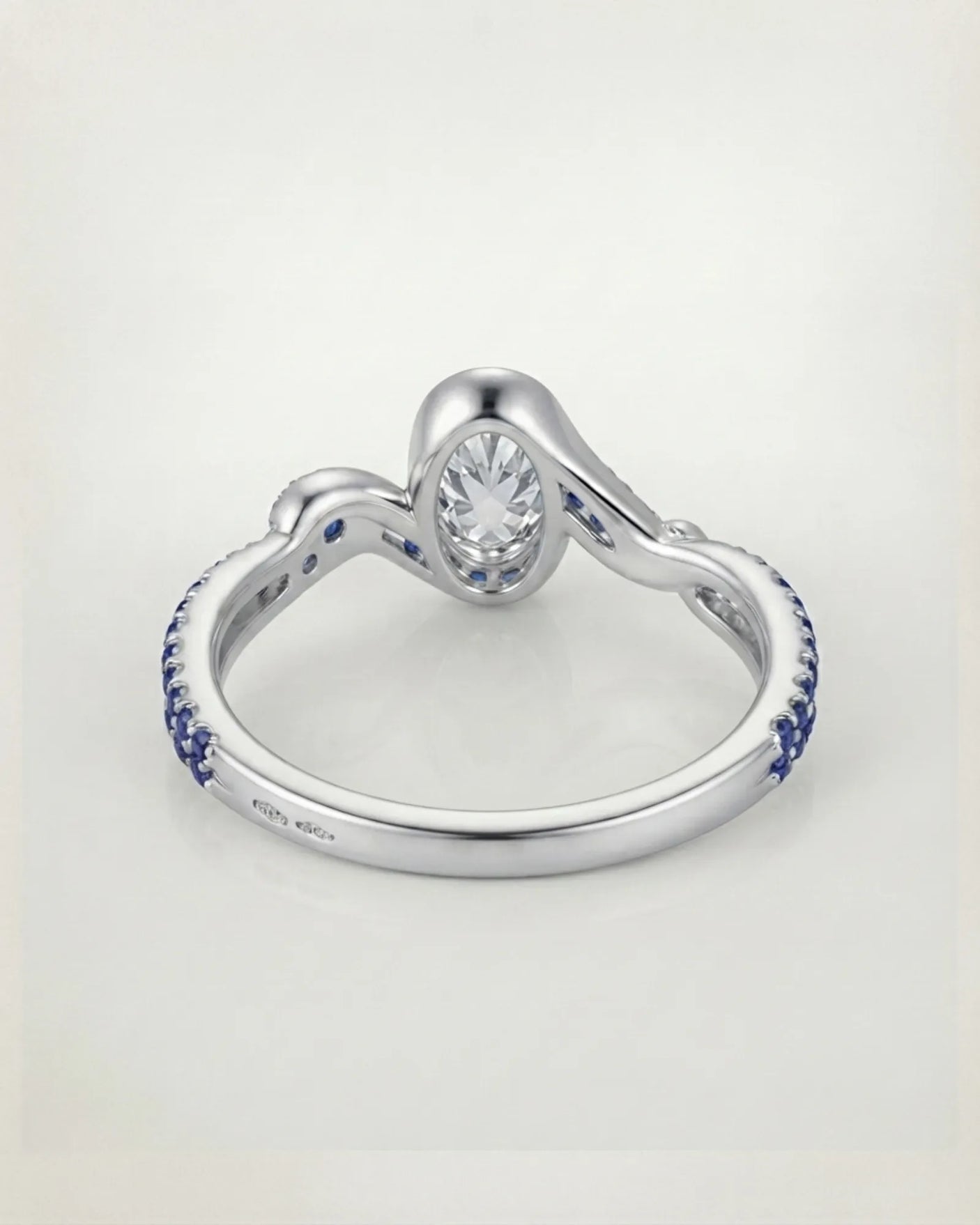 Luxury oval moissanite and natural sapphire ring with sculptural platinum ribbon setting | SARATTI