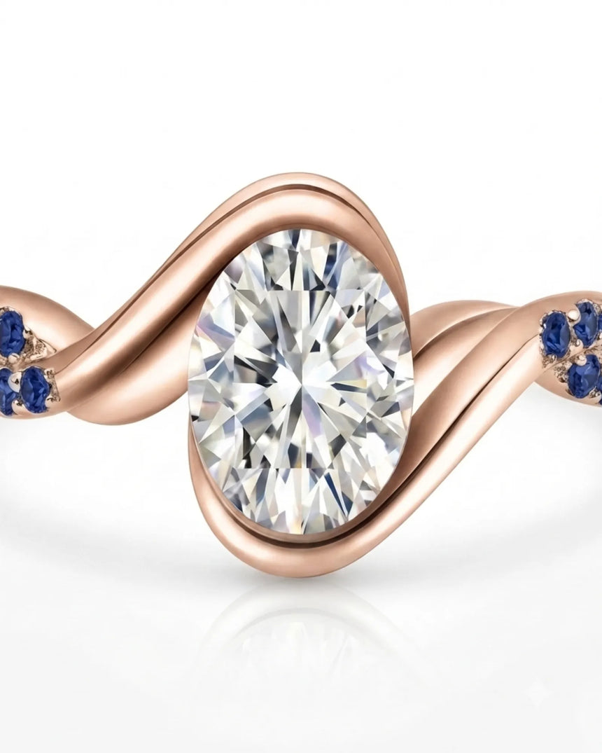 Luxury oval moissanite and natural sapphire ring with sculptural rose gold ribbon setting | SARATTI.
