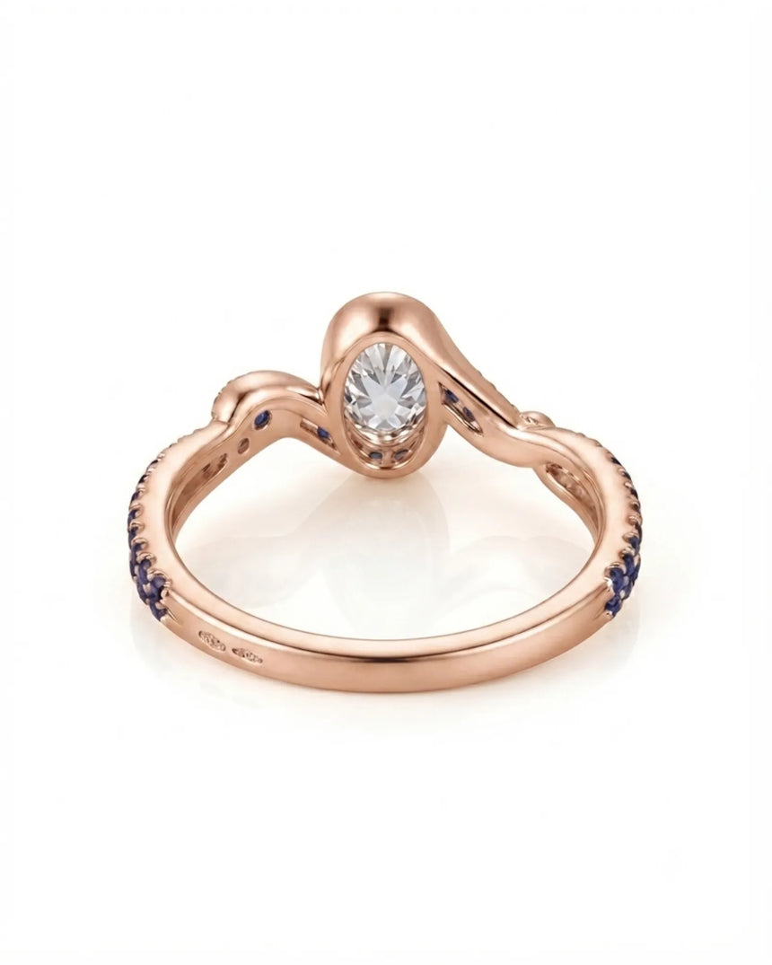Luxury oval moissanite and natural sapphire ring with sculptural rose gold ribbon setting | SARATTI